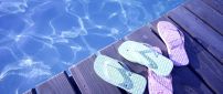 Blue and pink flip flop near the pool - Summer time