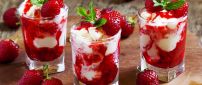 Cream and delicious red strawberries in glass cups