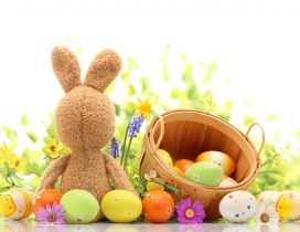 Fluffy Easter bunny with a basket full with painted eggs
