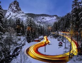 Car lights on the road in the mountains - Winter season