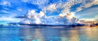 White clouds on the beautiful blue sky - Ocean mirror