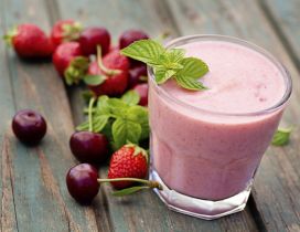 Delicious glass of smoothie with strawberry cherry and mint